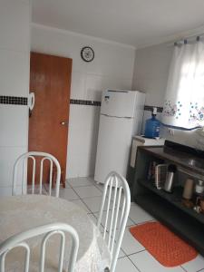a kitchen with a table and chairs and a refrigerator at Recanto do Sossego in Águas de Lindóia