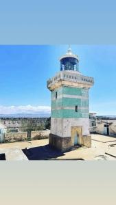 a lighthouse sitting on top of a building at Cap sim surf house in Essaouira