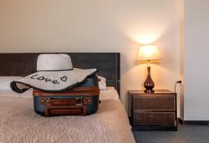 uma pilha de bagagem sentada numa cama com um chapéu em Hotel Beaumonde Garden em Tbilisi
