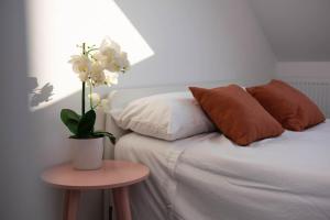 a bed with pillows and a table with a plant on it at Panorama House, Modern 3-Bedroom Apartment 3, Oxford in Kidlington