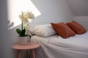 Bett mit Kissen und Tisch mit Pflanze drauf in der Unterkunft Panorama House, Modern 3-Bedroom Apartment 3, Oxford in Kidlington