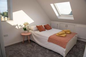 een slaapkamer met een bed met twee gele kussens erop bij Panorama House, Modern 3-Bedroom Apartment 3, Oxford in Kidlington