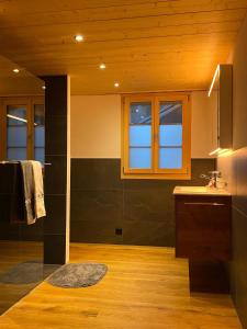 a kitchen with a counter and a sink and windows at Chalet Brünig in Meiringen