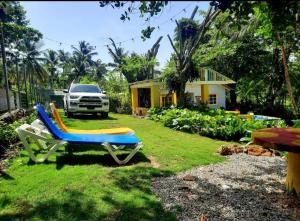 um quintal com uma cadeira, um camião e uma casa em La casita de la playa em La Entrada