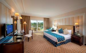 um quarto de hotel com uma cama e uma televisão de ecrã plano em Premier Le Reve Hotel & Spa Sahl Hasheesh - Adults Only 16 Years Plus em Hurghada