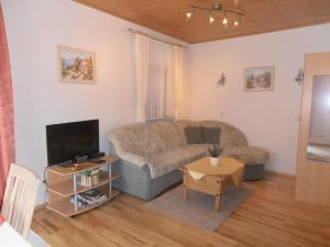 un soggiorno con divano e TV di Ferienwohnung-in-schoenster-Lage a Baar