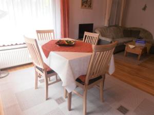 BaarにあるFerienwohnung-in-schoenster-Lageのダイニングルームテーブルと椅子(フルーツボウル付)