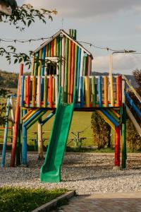 a colorful playground with a slide and a play structure at Cazare D&G in Şeíca Mare