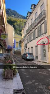 a car driving down a street next to buildings at Appartement grand standing plein centre ville in Cauterets