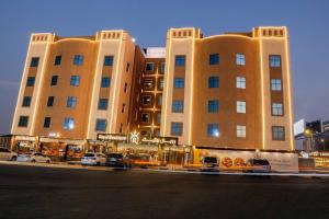 a large building with cars parked in front of it at Royal Boutique Hotel in Khamis Mushayt