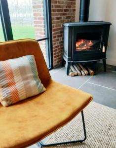 een stoel met een kussen voor een open haard bij Gite Le Clos Sainton in Saint-Hilaire-Saint-Mesmin