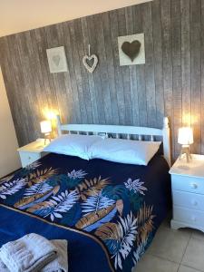 una camera da letto con un letto con un piumone blu di Lac Cimes a Pagéas