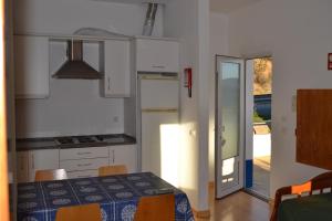 a kitchen with a table and a door to a patio at HI Alcoutim – Pousada de Juventude in Alcoutim