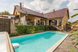 uma casa com piscina em frente a uma casa em Luxusní vila v Rudici 