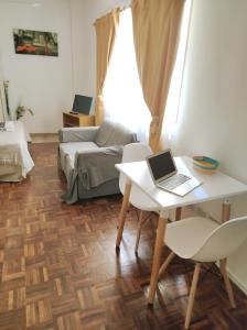 uma sala de estar com uma secretária e um computador portátil sobre uma mesa em Vuelta de Obligado Apartment em Buenos Aires
