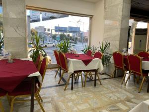 a restaurant with two tables and chairs and a window at Hotel Zaitona in Erbil