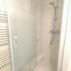 La salle de bains est pourvue d'une douche avec une porte en verre. dans l'établissement Spacieux studio dans résidence avec parking privé, à Clermont-Ferrand