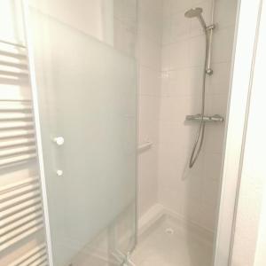 prysznic ze szklanymi drzwiami w łazience w obiekcie Spacieux studio dans résidence avec parking privé w mieście Clermont-Ferrand