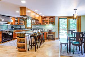 una cocina con armarios de madera y un bar con taburetes en Coolidge Drive Retreat, en Quechee