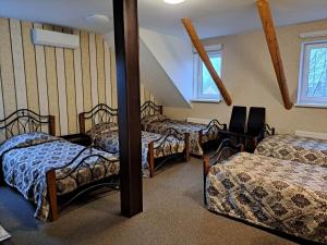 a room with three beds and a mirror at Buožinta in Buožėnai