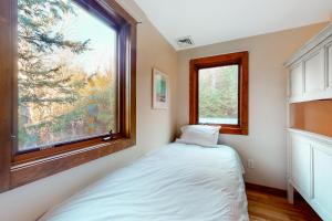 Habitación pequeña con cama y ventana en Coolidge Drive Retreat, en Quechee