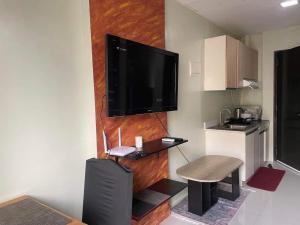 een woonkamer met een flatscreen-tv aan de muur bij Bamboo Bay Condominium T1 in Nawanao