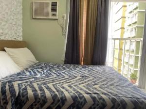 een slaapkamer met een bed en een raam met een raam bij Bamboo Bay Condominium T1 in Nawanao