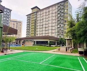 een tennisbaan voor een groot gebouw bij Bamboo Bay Condominium T1 in Nawanao