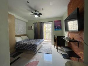 een slaapkamer met een bed, een tv en een raam bij Bamboo Bay Condominium T1 in Nawanao