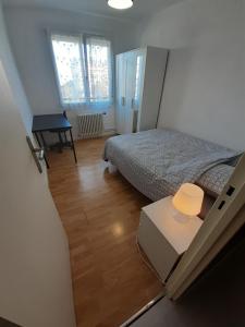 um pequeno quarto com uma cama e uma mesa em 3 chambres NETFLIX INCLUS em Troyes