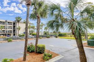a parking lot with palm trees in front of a building at Sea Side Villas 163 in Hilton Head Island