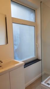 een badkamer met een raam en een wastafel bij B44 appartment in Brussel