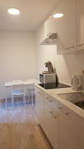een keuken met witte kasten en een tafel met stoelen bij B44 appartment in Brussel