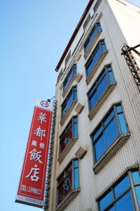 a building with a red sign on the side of it at Hwa Du Hotel in Tainan