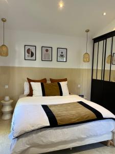 a large bed in a bedroom with two pendant lights at Suite La Farigoulette in Marseille