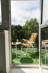patio con mesa y sillas en el balcón en Tree&Lake Apartament Warszawa en Ząbki