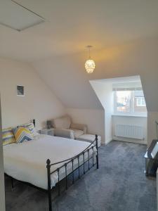 a bedroom with a large bed and a couch at Spacious Ensuite King Room Private Neighbourhood Free Parking Space in Oldham