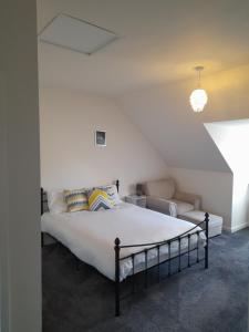 a bedroom with a bed and a couch at Spacious Ensuite King Room Private Neighbourhood Free Parking Space in Oldham