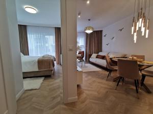 a living room with a bedroom and a dining room at Gold Apartment B33 Let's Sea Baltic Park Gąski in Gąski
