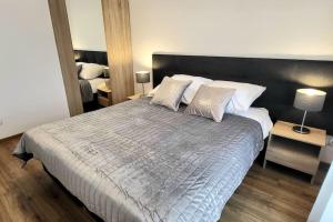 a bedroom with a large bed with white sheets and pillows at Modern Silver Apartment 2 rooms Bosacka Old Town in Krakow