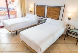 two beds in a room with a balcony at Hotel Oh Nice Caledonia in Estepona