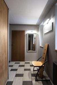 einen Flur mit einem Stuhl und einem Spiegel an der Wand in der Unterkunft Klimatyczny dom w Krakowie in Krakau