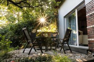 een patio met 4 stoelen, een tafel en een raam bij Klimatyczny dom w Krakowie in Krakau