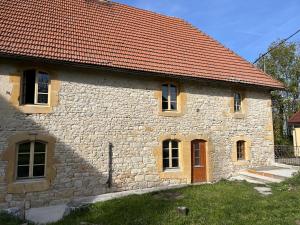 an old stone house with a red roof at Le gite de Longcochon in Longcochon