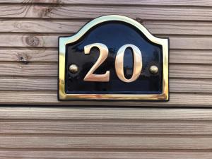 a house number sign on a wooden wall at Delightful 2-bed static set in a peaceful village in Gilcrux