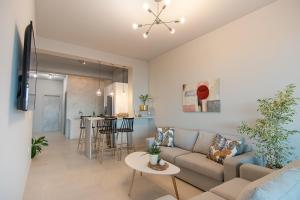 a living room with a couch and a table at Georgianna's suite with private pool , 'blank suite' in Kharokopión