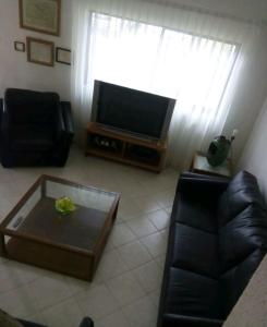 uma sala de estar com um sofá e uma televisão em Delfin bnb em Cruz de Huanacaxtle