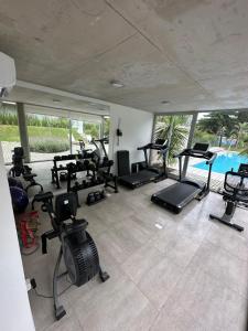 un gimnasio con una gran cantidad de equipos de ejercicio y una piscina en Apartamento a estrenar en complejo Mansa inn2 en Punta del Este