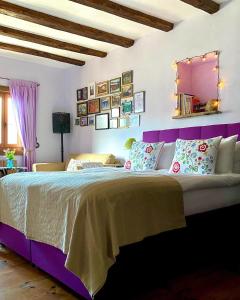 Schlafzimmer mit einem großen Bett mit einem lila Kopfteil in der Unterkunft Lavanda Restaurant with Rooms in Kovachevitsa