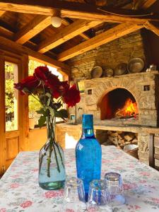 a table with a vase of roses and a fireplace at Lavanda Bed and Breakfast in Kovačevica